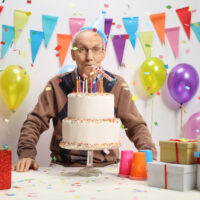 old man celebrating birthday with cake
